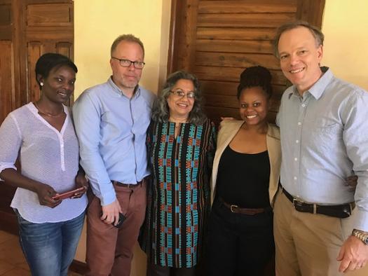 Paul (far right) and Anu (center) with EDI staff at their office in Dar es Salaam.