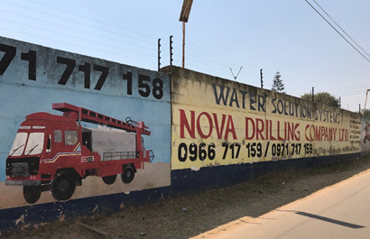 Borehole drilling companies line a main street in Lusaka, Zambia. Companies like this one are flourishing in the city. The unreliable water supply has pushed residents to build their own private boreholes, which are an expensive solution to the water problem.