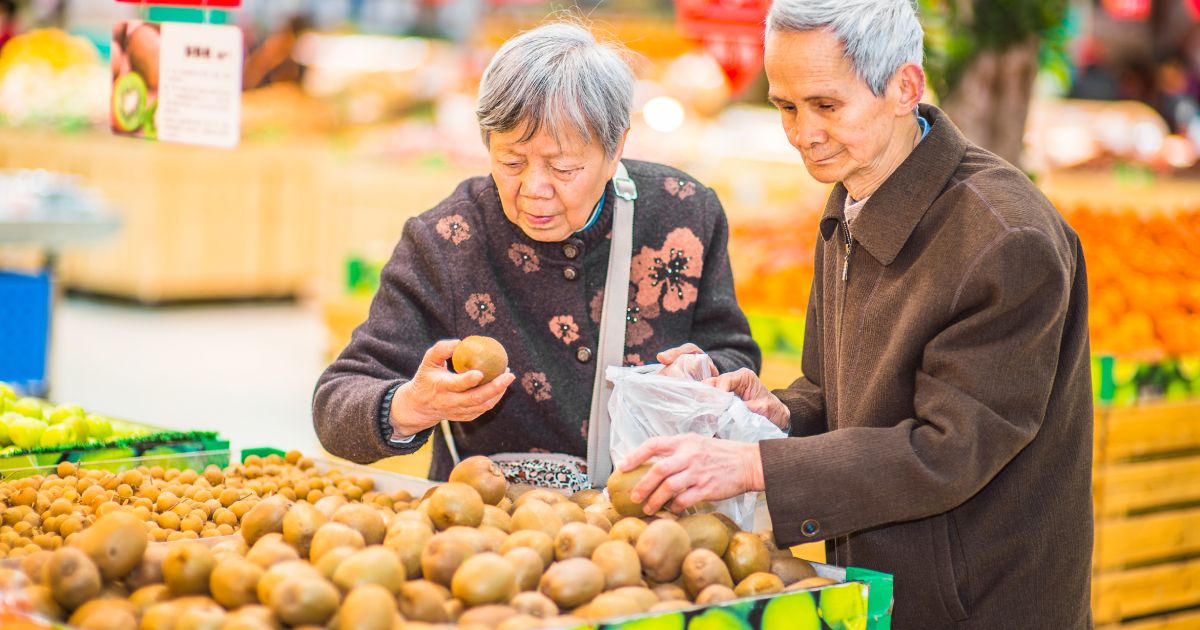 Older couple selecting potatoes in a grocery store